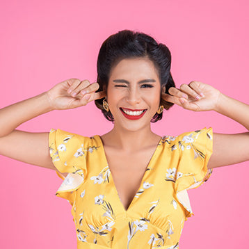 Woman wincing with fingers in ears